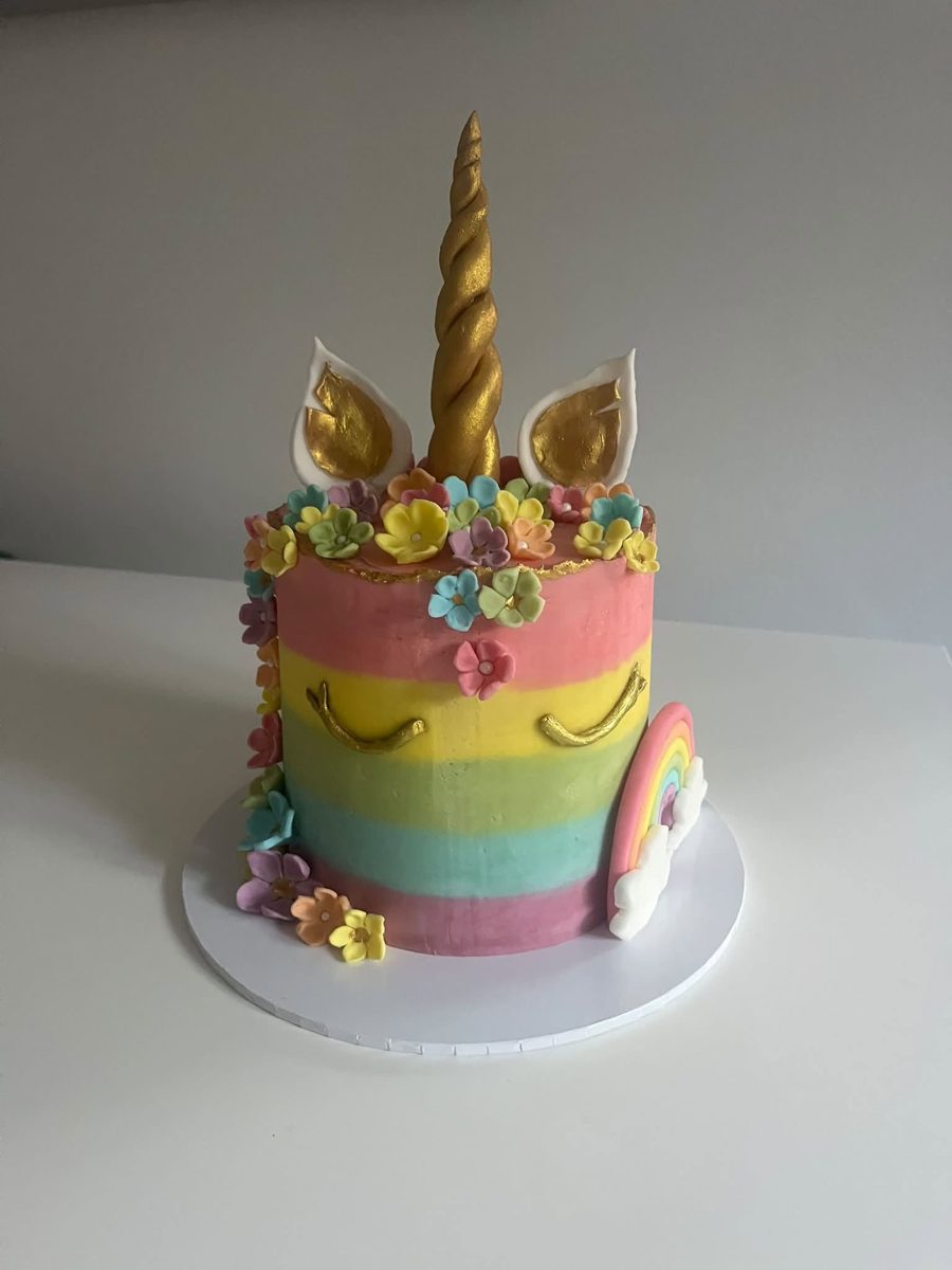 Rainbow unicorn cake with a gold horn and sugar flowers